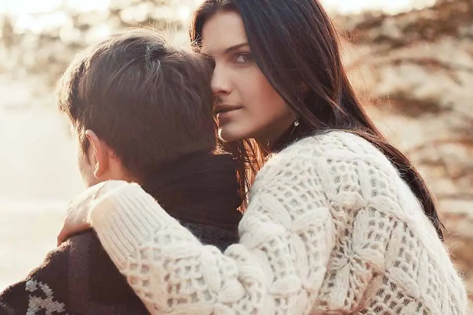 woman in white sweater hugging her man